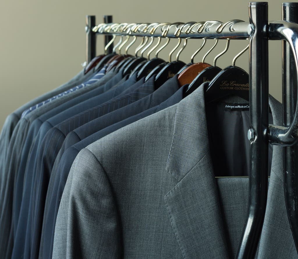 Photograph of business suits hung on a line.