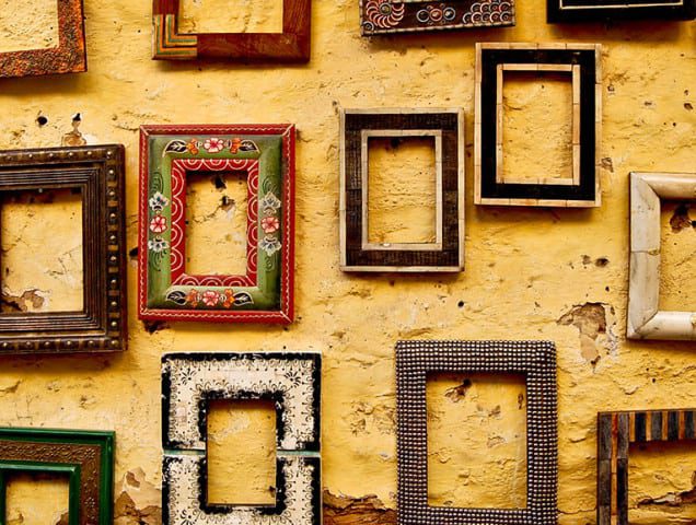Photograph of empty picture frames on a wall.