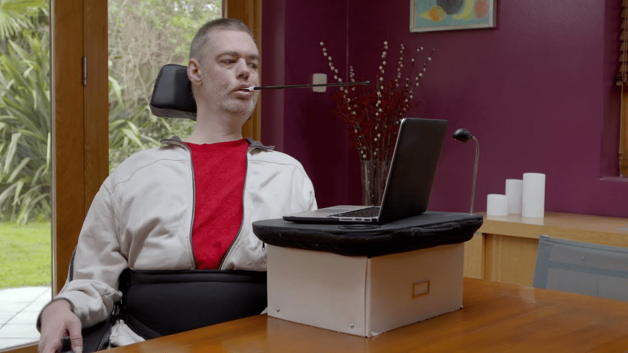 Wheelchair user operating a computer with a mouth-held wand